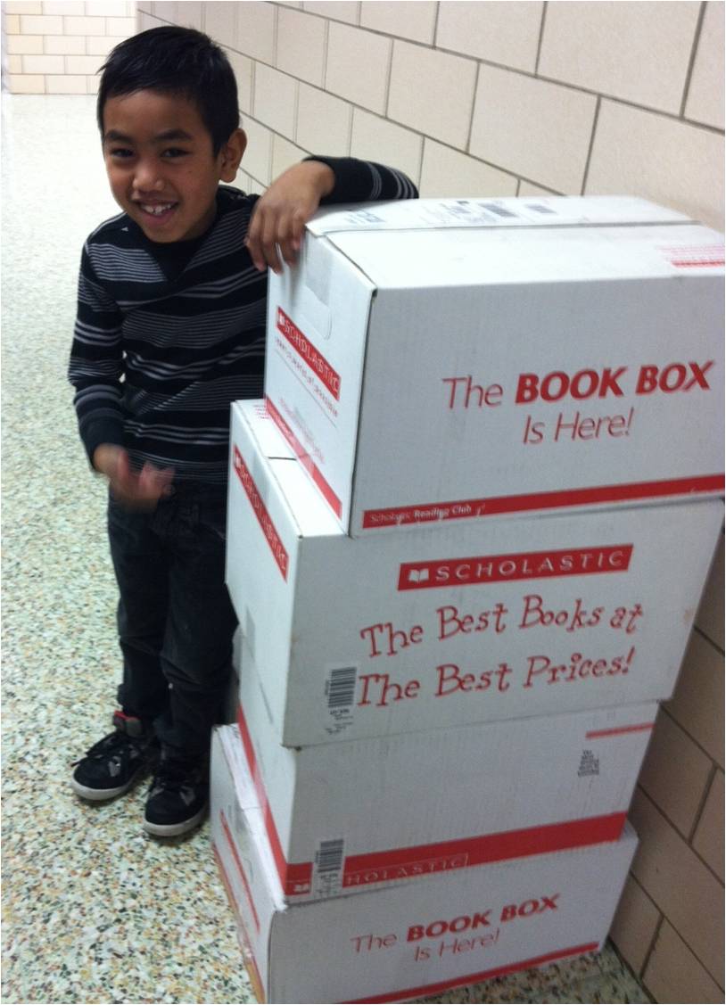 Student Jasber with boxes of books as tall as he is