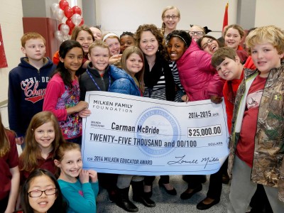 Carman McBride poses with her students and check