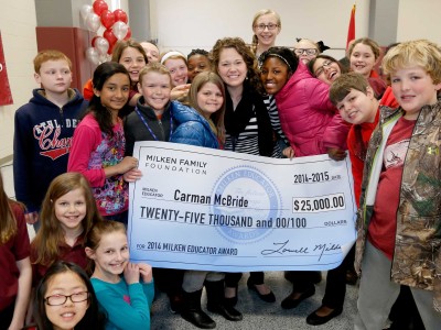 Carman McBride poses with her students and check