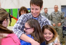 Jenna White hugged by children w soldiers