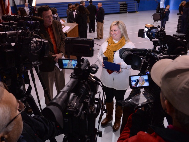 Krystle Bryant surrounded by media cameras