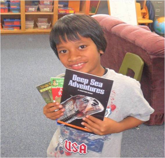 Student TJ with three of his very own books